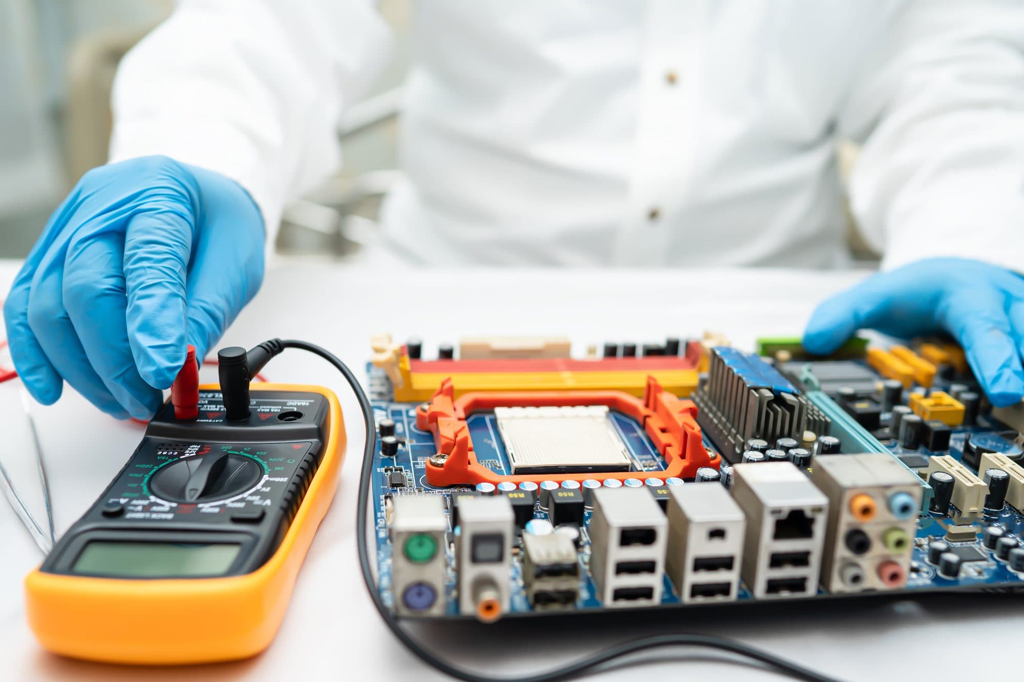 Mesure au multimètre sur une carte électronique lors d'un diagnostic de non-conformité